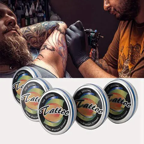 Tatuador trabajando en el pecho de un cliente con botes de bálsamo